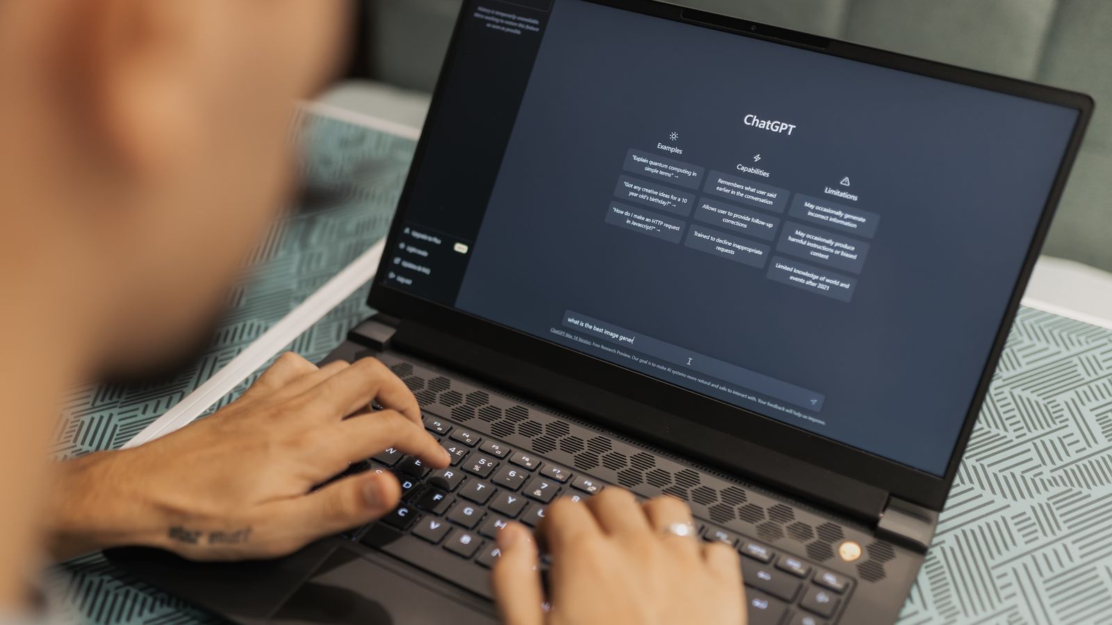 Les mains d'un marketeur qui tape une requête dans un assistant IA sur son ordinateur portable