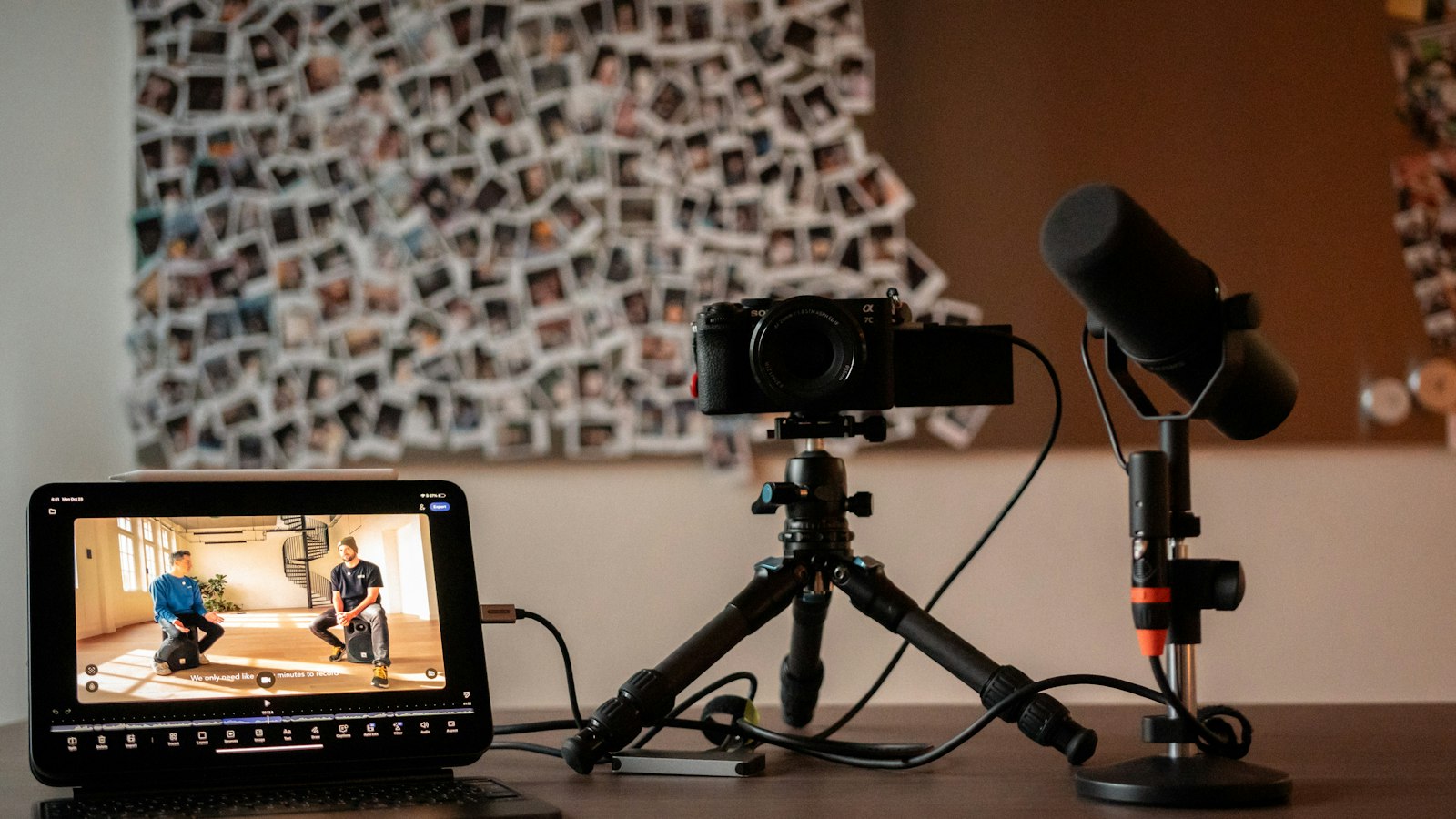 Un poste de tournage avec une caméra sur trépied, un micro et une tablette qui affiche un montage vidéo